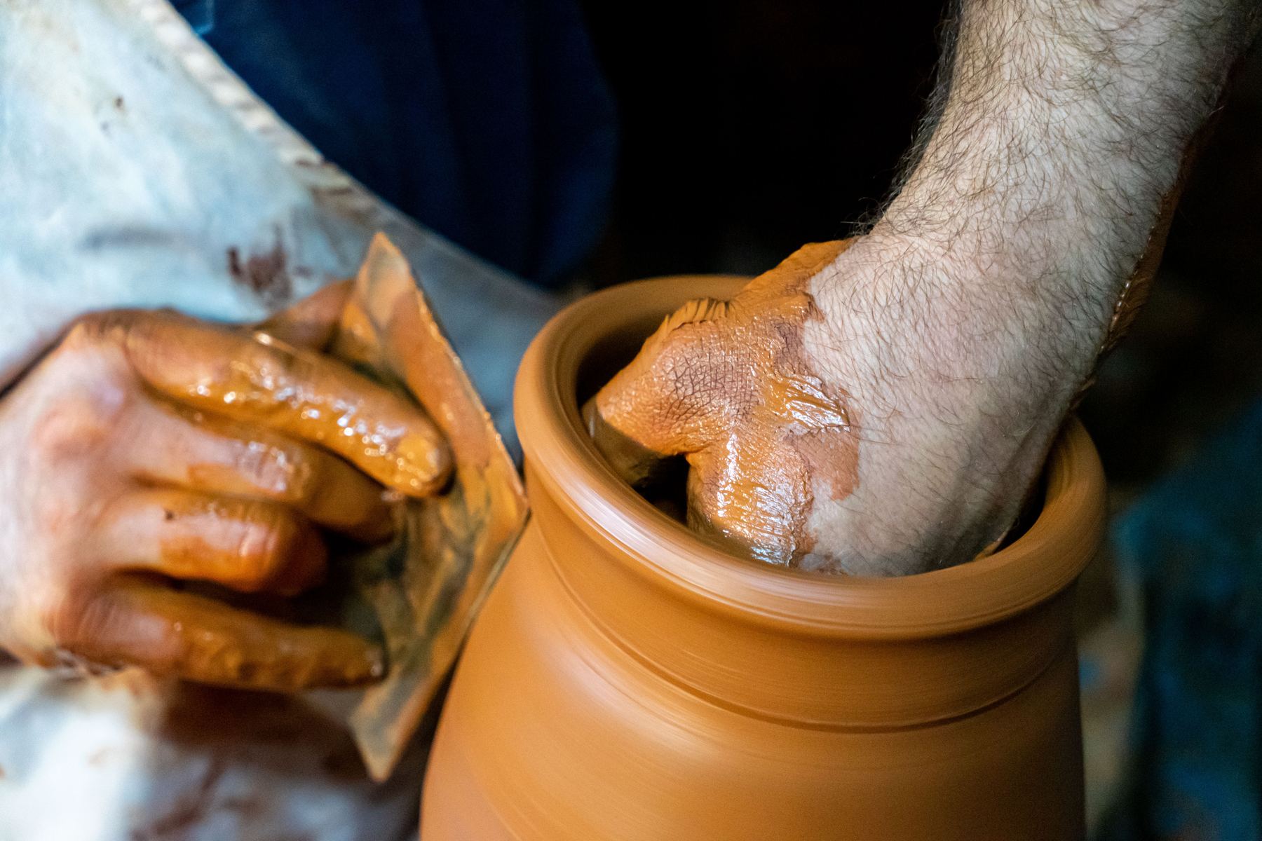 Hands centering clay on a pottery wheel