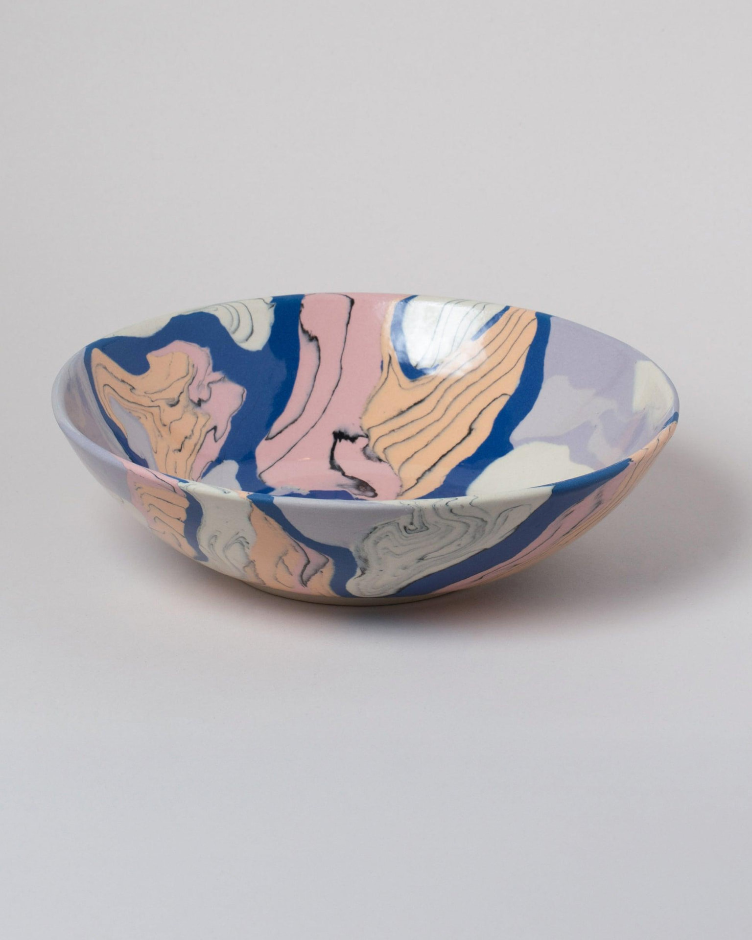 Nerikomi bowl with flowing layers of pink, blue, peach, and cream colored clay